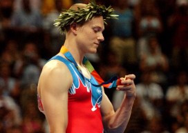 Un gymnaste regarde sa médaille d'or lors de la cérémonie des médailles