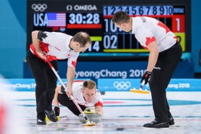 Trois joueurs de curling en action