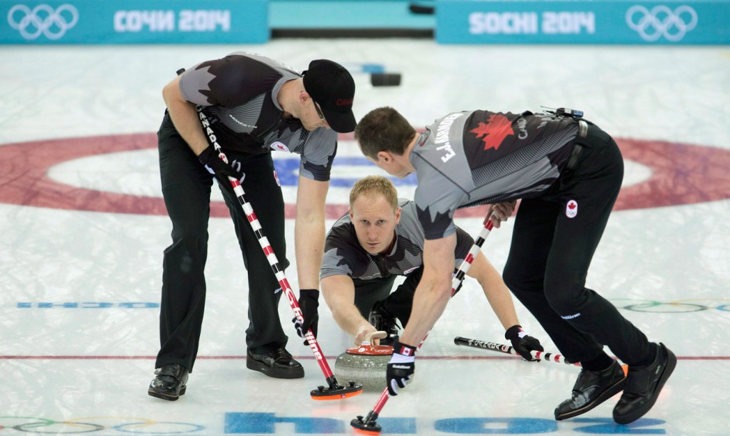 Trois joueurs de curling en action