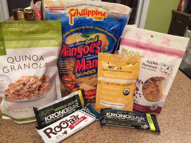 Collations assorties : mangues et pommes séchées, granola de quinoa pour le déjeuner, amandes et barres de protéine