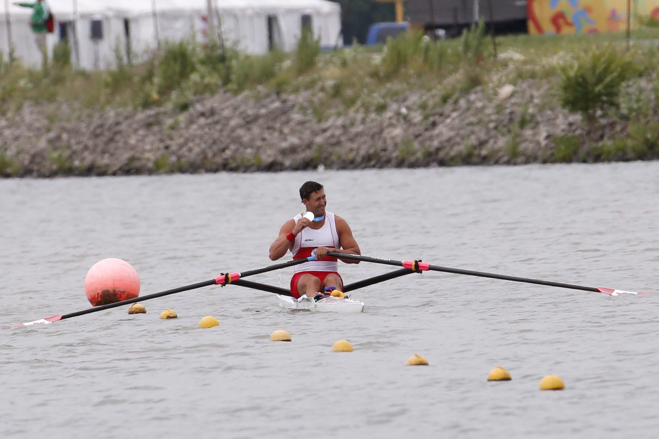 Rob Gibson (skiff) exhibe sa médaille d’argent en ramant lors des Jeux panaméricains de 2015. (AP Photo/Julio Cortez)