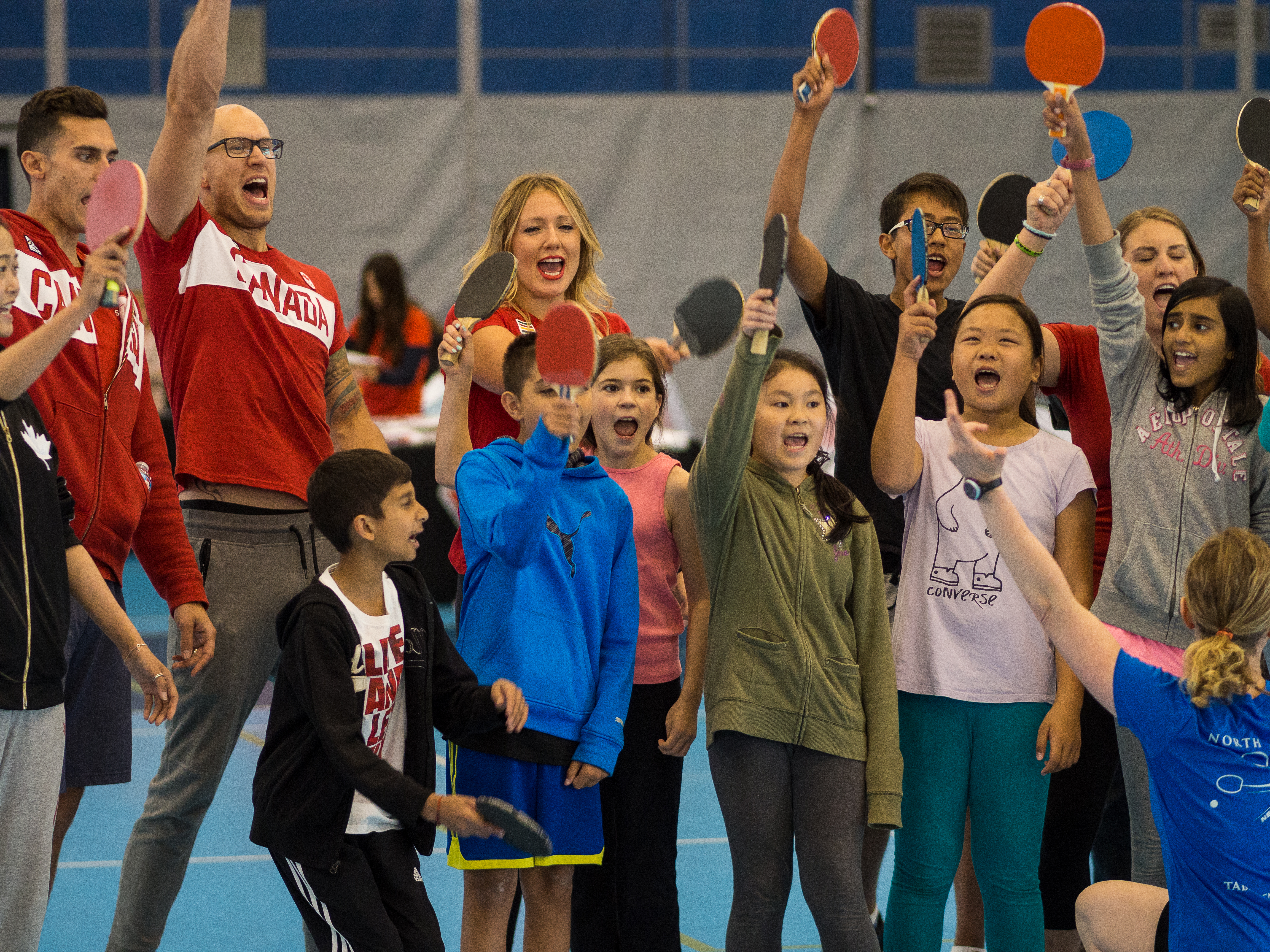 L'olympien Brent Hayden et les jeunes présents à l'atelier de tennis de table supervisé par Mo Zhang et Eugene Wang à la journée olympique de Richmond le 14 juin 2016.
