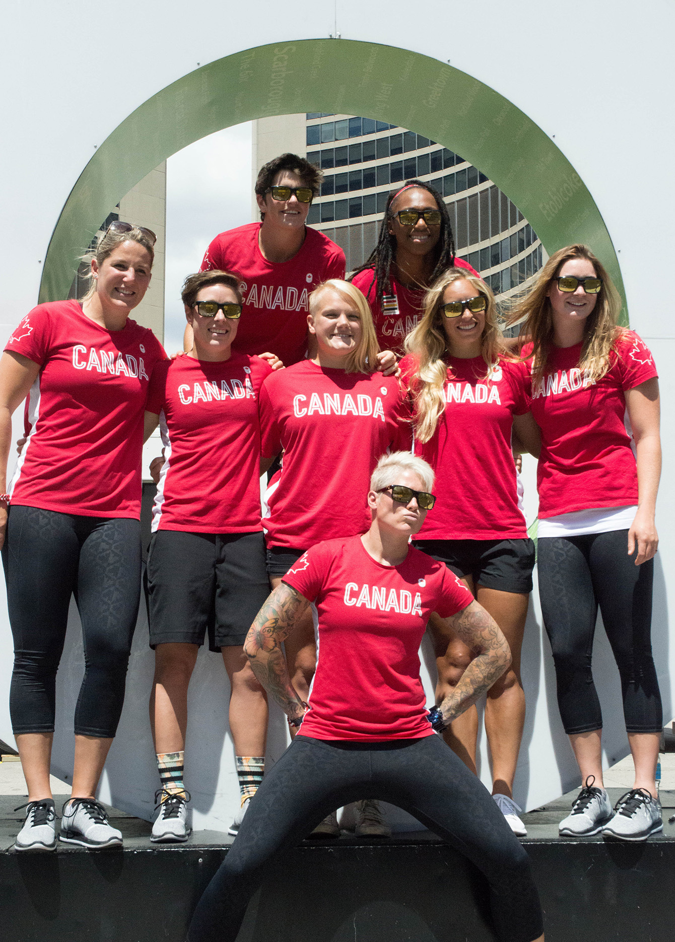 Quelques membres de l’équipe de rugby devant le signe de « Toronto » au Nathan Phillips Square, le 26 juillets 2016. (Tavia Bakowski/COC)