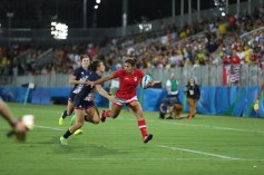 Une joueuse de rugby évite un plaqué lors d'un match