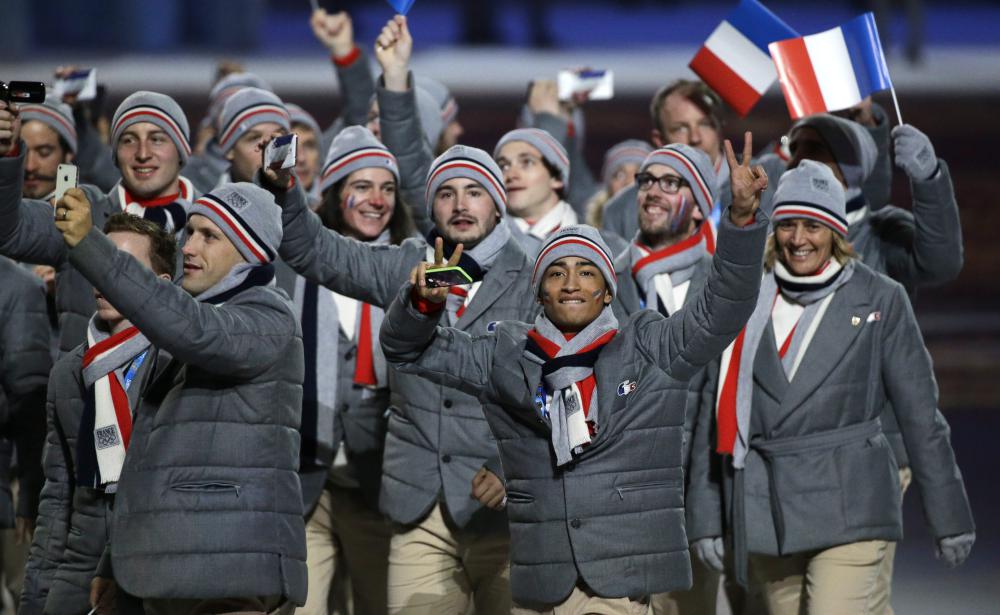 Le patineur Florent Amodio de France, au premier plan à droite, salue la foule lors de la cérémonie d'ouverture des Jeux olympiques d'hiver de 2014 à Sotchi, en Russie, le vendredi 7 février 2014. (AP Photo / Mark Humphrey)