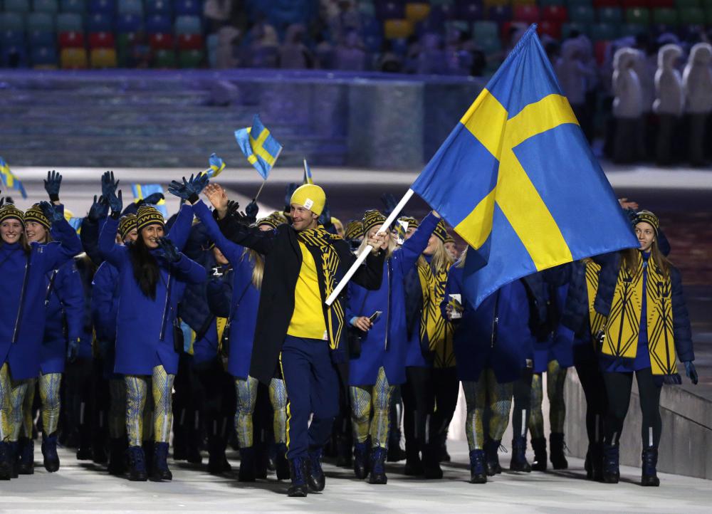 Anders Soedergren de Suède porte le drapeau national lors de la cérémonie d'ouverture des Jeux olympiques d'hiver de 2014 à Sotchi, en Russie, le vendredi 7 février 2014. (AP Photo / Mark Humphrey)