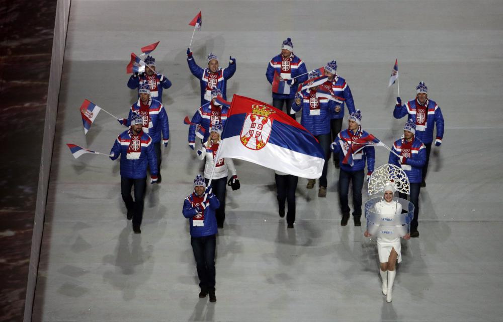 Milanko Petrovic de Serbie porte le drapeau national lors de la cérémonie d'ouverture des Jeux olympiques d'hiver de 2014 à Sotchi, en Russie, le vendredi 7 février 2014. (AP Photo / Charlie Riedel)