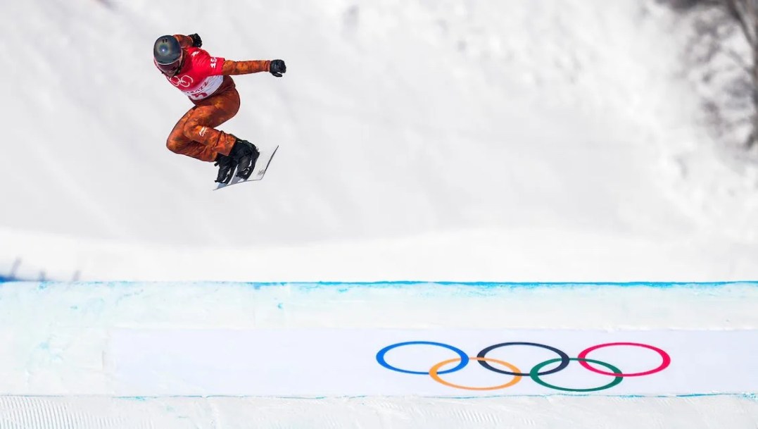 Un athlète de snowboard cross effectue un saut