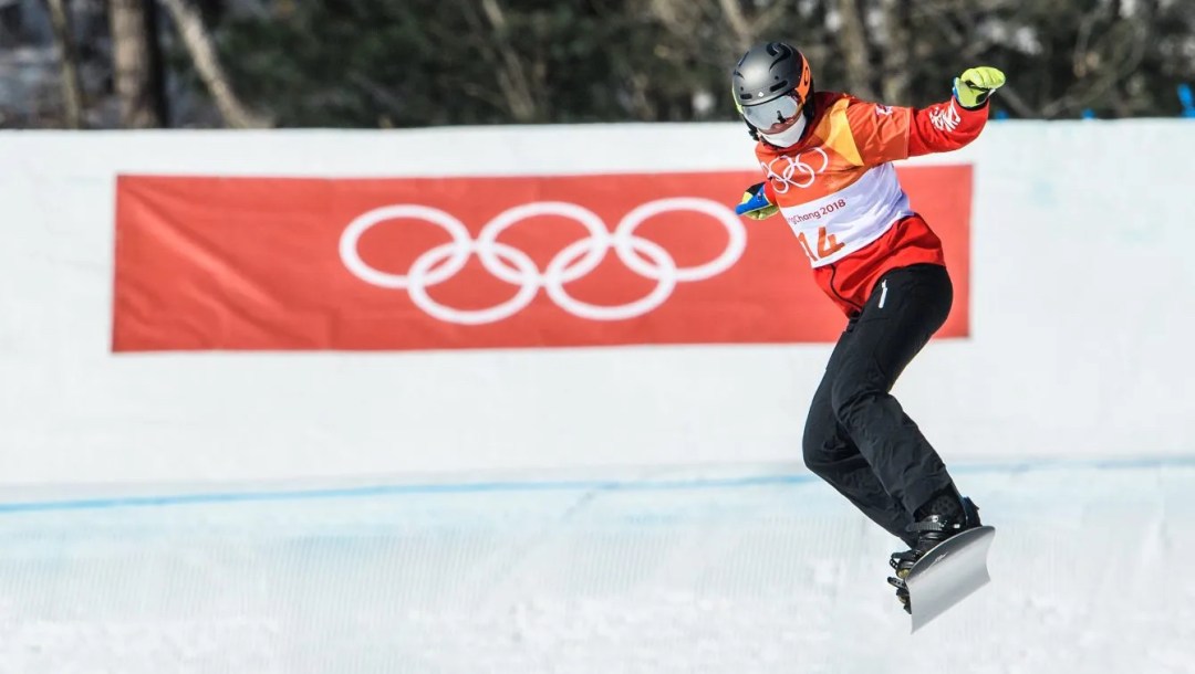 Une athlète de snowboard cross en action lors d'un saut