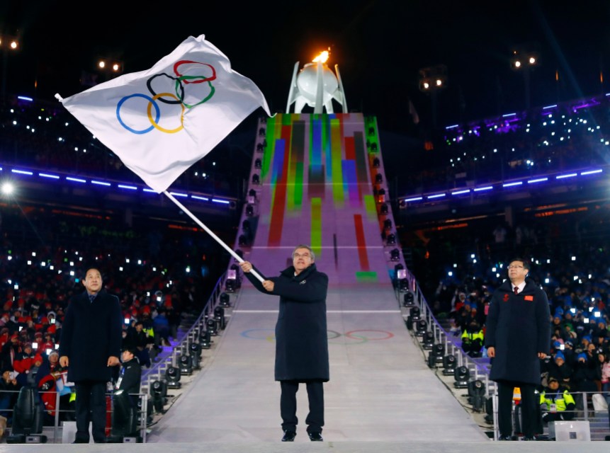 Pyeongchang Olympics Closing Ceremony Le président du Comité olympique international, Thomas Bach, brandit le drapeau olympique, accompagné du maire de PyeongChang, Sim Jae-guk (gauche), ainsi que le maire de Beijing, Chen Jining (droite), lors de la cérémonie de clôture. (Kai Pfaffenbach/Pool Photo via AP)