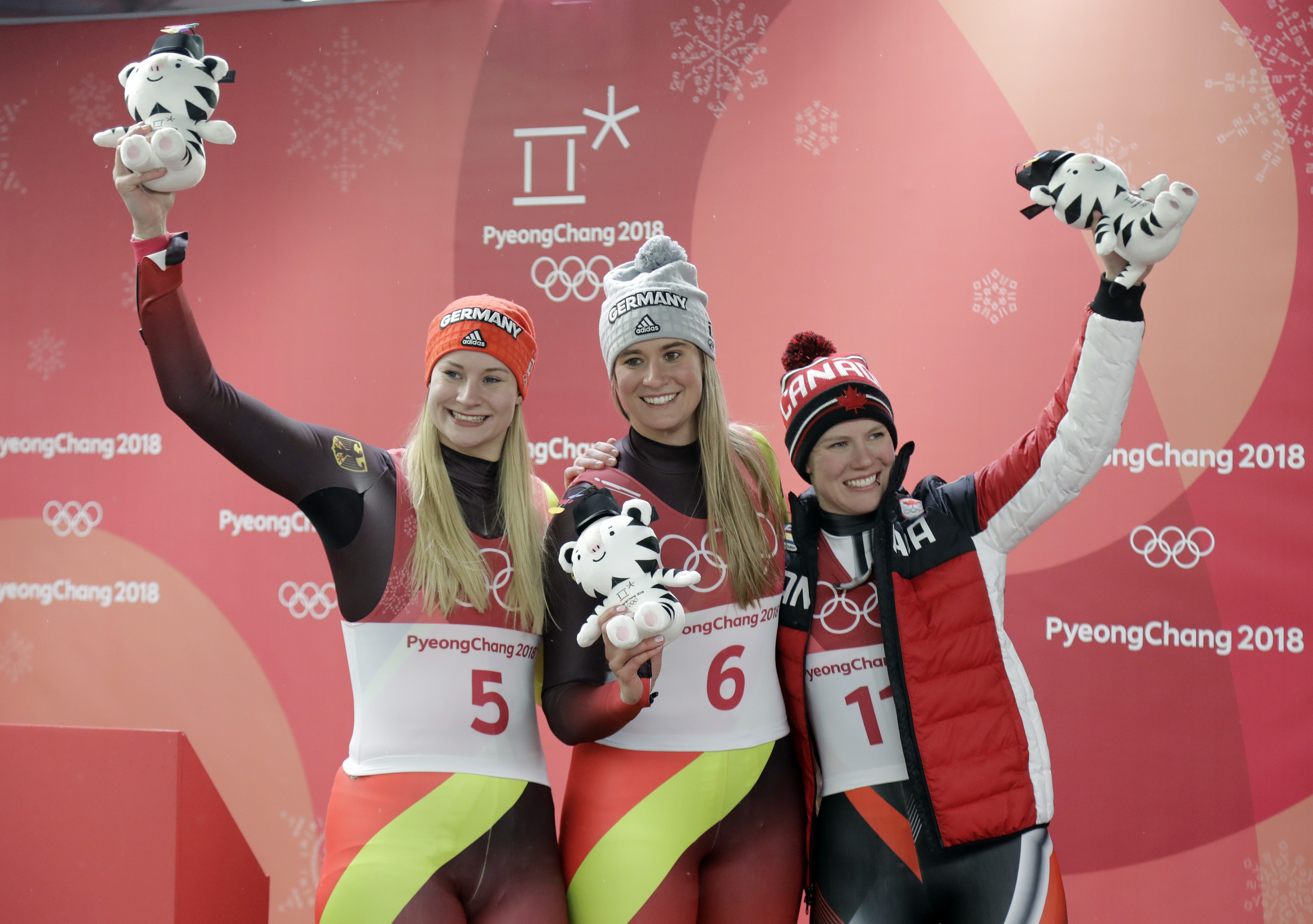 De gauche à droite, la médaillée d'argent Dajana Eitberger de l'Allemagne, la médaillée d'or Natalie Geisenberger de l'Allemagne, et Alex Gough, médaillée de bronze, à l'épreuve simple de luge aux Jeux olympiques de PyeongChang, le 13 février 2018. (AP Photo/Wong Maye-E)