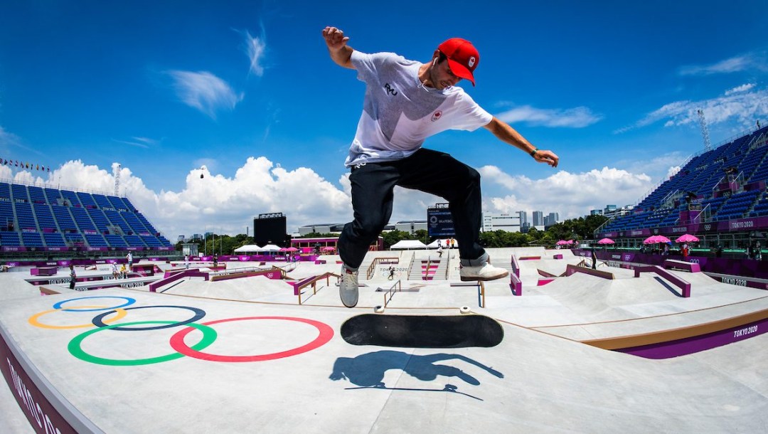 Un athlète saut sur un skateboard.