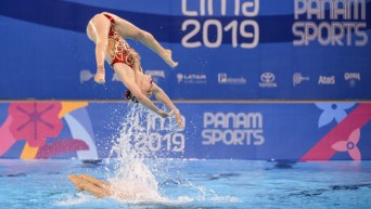 Une nageuse artistique en plein saut hors de l'eau