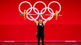 Maude Charron soulève une barre au dessus de sa tête sur la plateforme à Tokyo 2020