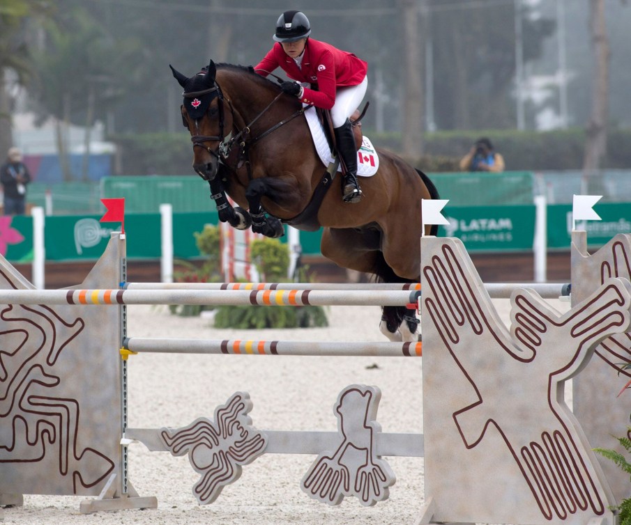 Un cavalier d'Équipe Canada et sa monture sautent par dessus un obstacle à Lima 2019