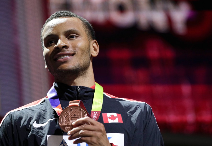 Andre De Grasse souriant avec sa médaille de bronze à la main aux Mondiaux de l'IAAF