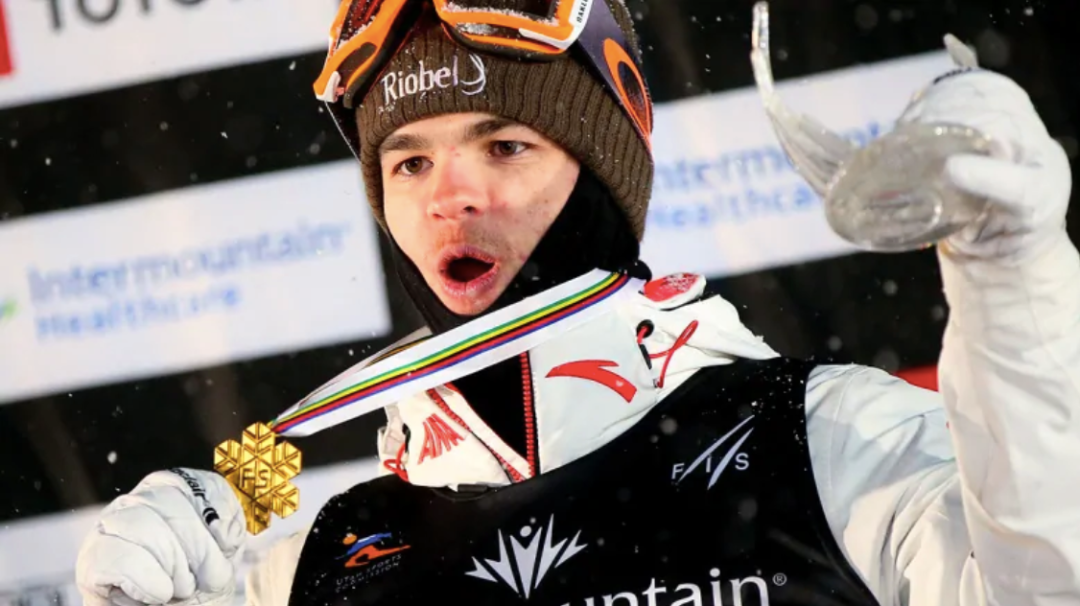 Mikaël Kingsbury montre sa médaille d'or sur le podium