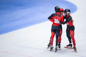 Trois patineurs canadiens se serrent dans leurs bras