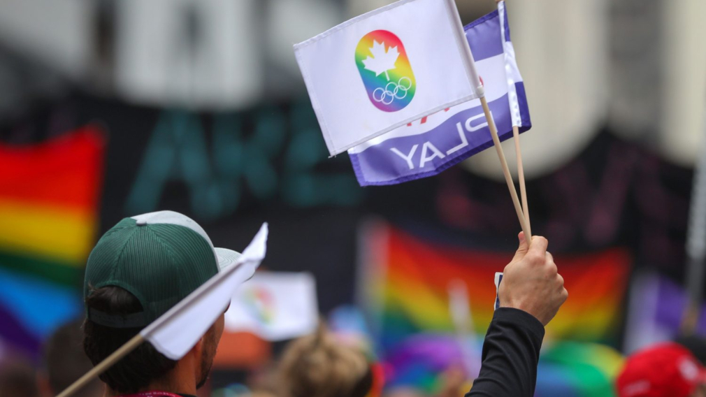 Un drapeau arc en ciel pendant une manifestation.