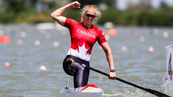 Laurence Vincent Lapointe lève le poing en l'air après avoir traversé la ligne d'arrivée d'une compétition de canoë de vitesse