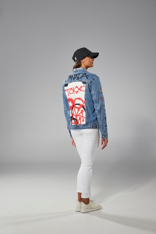 Kylie Masse porte un jeans blanc, un t-shirt noir et une veste en jeans