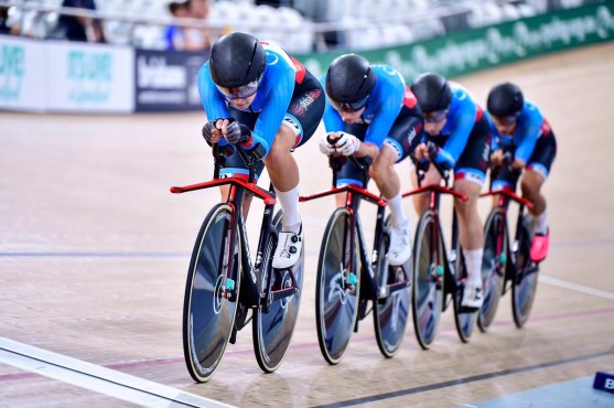 quatre femmes se suivent lors d'une course de poursuite par équipes dans un vélodrome