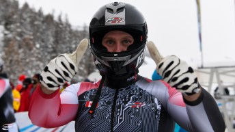 Un athlète de bobsleigh fait les signes du pouce vers le haut après sa descente.