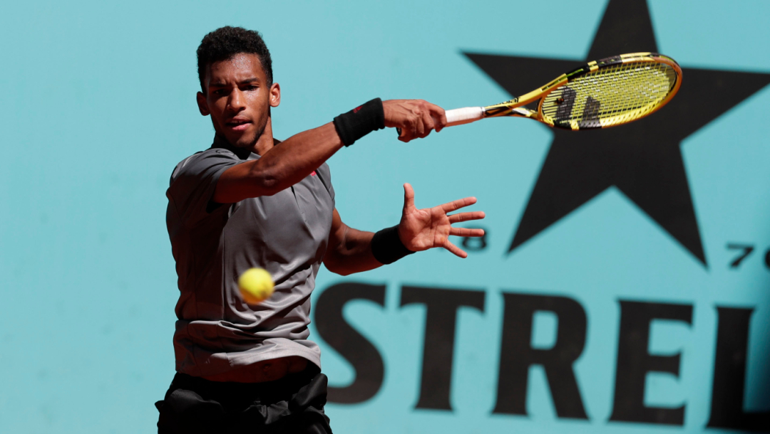 Felix Auger-Aliassime frappe une balle face à la caméra.