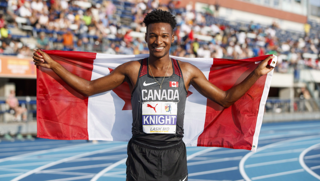 Justyn Knight pose avec le drapeau canadien.