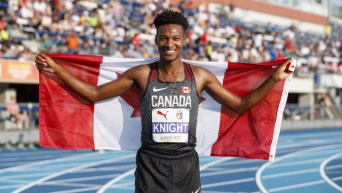 Justyn Knight pose avec le drapeau canadien.