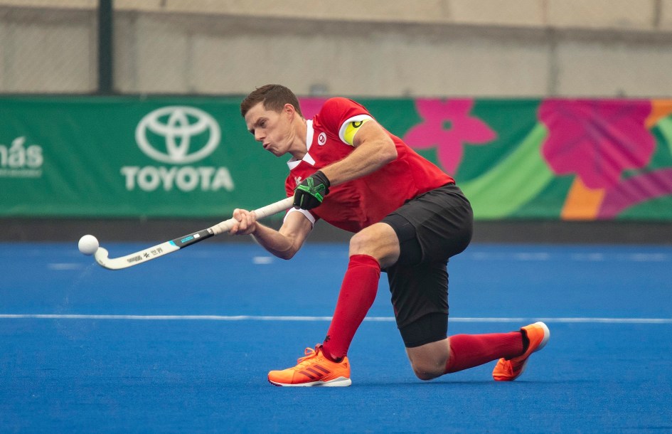 Un joueur de hockey sur gazon frappe la balle