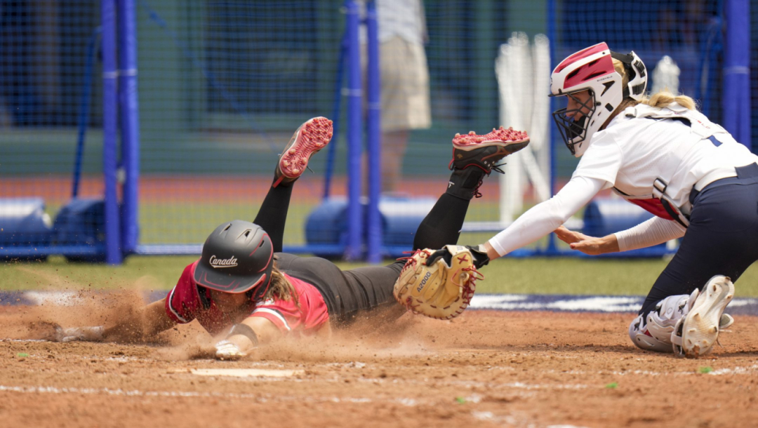 Joey Lye glisse au marbre et est est retirée lors d'un match de softball.