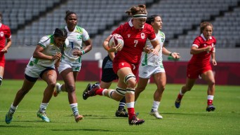 Une joueuse de rugby porte le ballon.