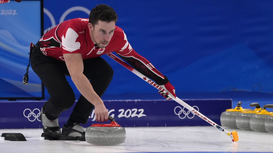 Un joueur de curling se prépare à lancer sa pierre