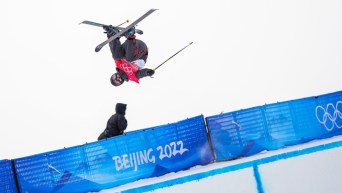 Une skieuse acrobatique effectue un saut sur la demi-lune