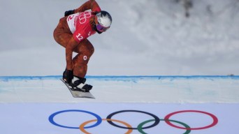 Une athlète de snowboard cross descend la pente