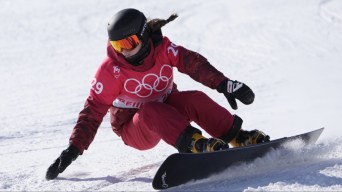 Une athlète de snowboard dévale la pente à toute vitesse