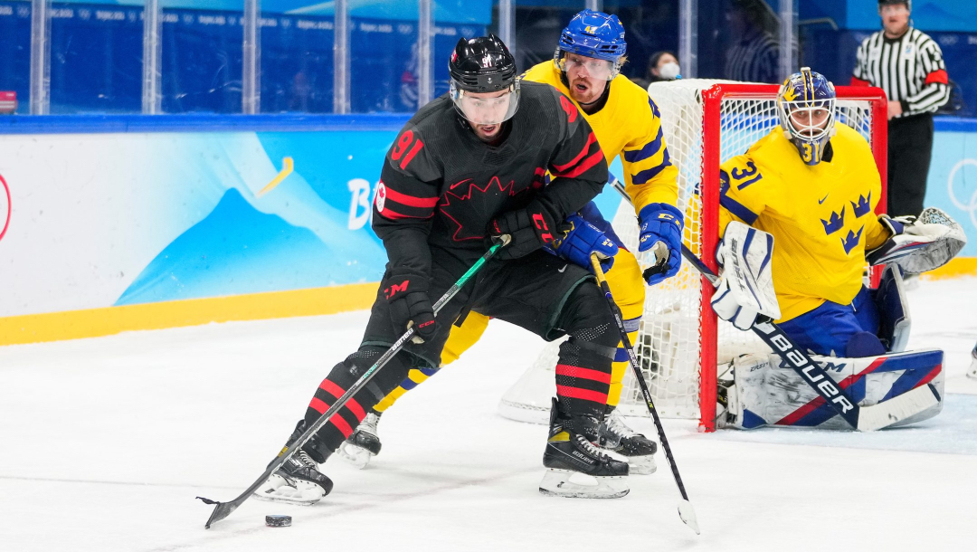 Un joueur de hockey défend la rondelle près du filet