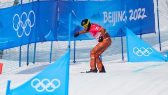 Un athlète de snowboard cross effectue sa descente