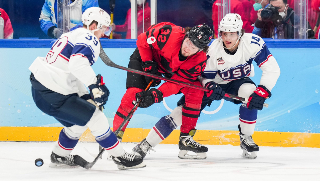 Trois joueurs de hockey se disputent la rondelle