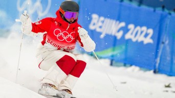 Une skieuse acrobatique descend la pente à l'épreuve de bosses