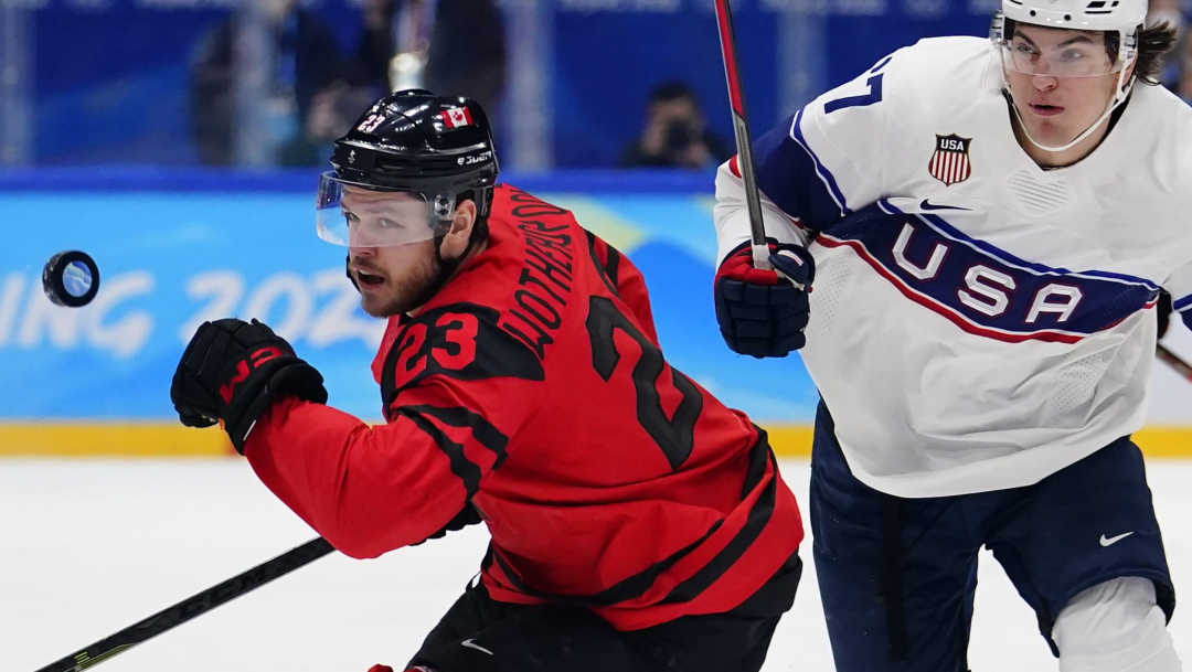 Deux joueurs de hockey se dirigent vers la rondelle qui est en plein vol