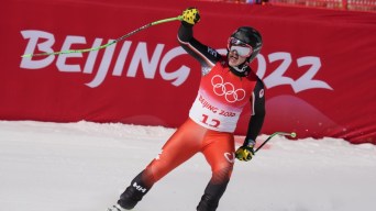 Le Canadien Jack Crawford lève la main droite en célébration après sa course de descente masculine à Beijing 2022.