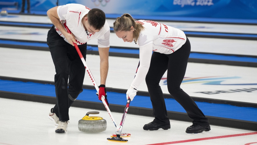 Rachel Homan et John Morris balayent une pierre.