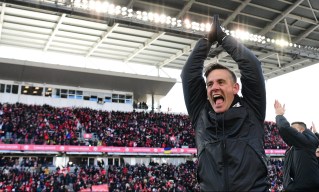 Herdman lève les deux bras dans la airs pour célébrer.