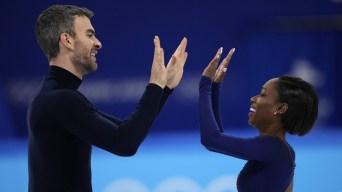 Eric Radford et Vanessa James se regardent et se tapent dans les mains.