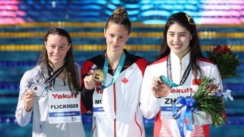 Summer McIntosh tient sa médaille d'or dans la main.