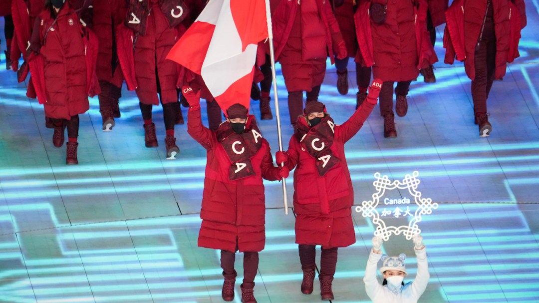 Deux porte-drapeaux entrent dans le stade.