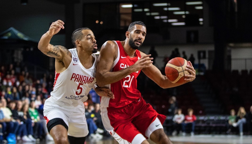 Deux joueurs de basketball se disputent le ballon.