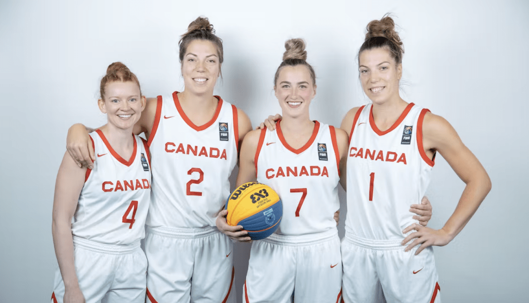 Quatre joueuses de basketball posent pour la caméra.